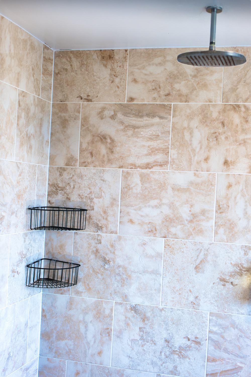 Walk-in rainfall shower with stone-effect tiles in the suite’s private en-suite
